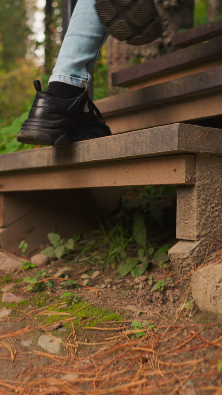 Woman steps on stairs leading to cottage. Young woman returns from walk in forest alone. Forest embraces with symphony of natural sounds