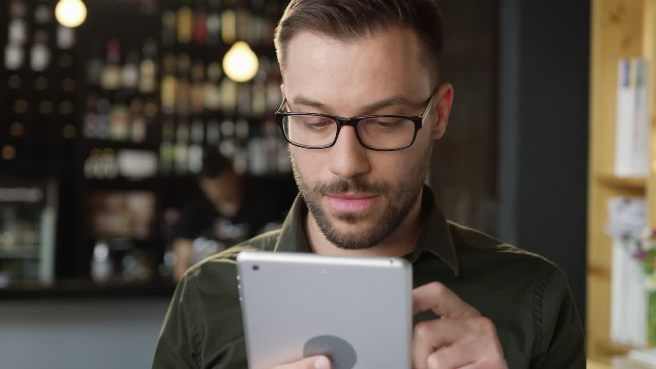 hombre usa tableta en café desde varios ángulos