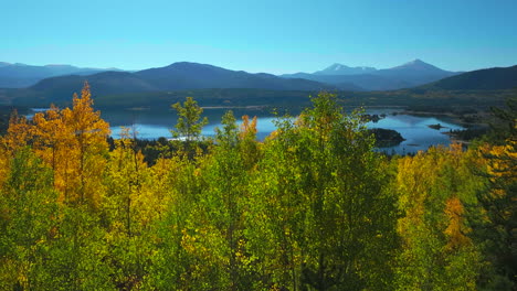 early fall yellow colors aspen trees lake dillon colorado aerial cinematic drone morning view frisco breckenridge silverthorne ten mile range calm reflective water wide dolly jib upward movement