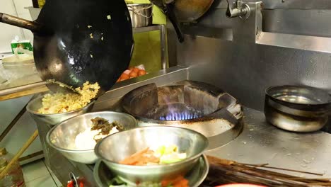 chef prepares pineapple fried rice in a wok