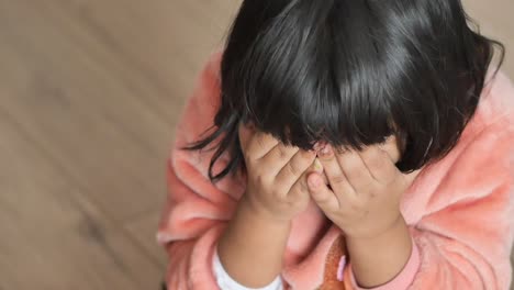 a young girl covering her face