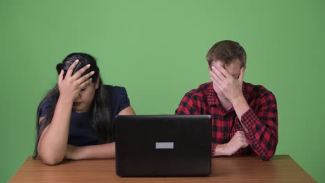 joven pareja de negocios multiétnica juntos contra un fondo verde