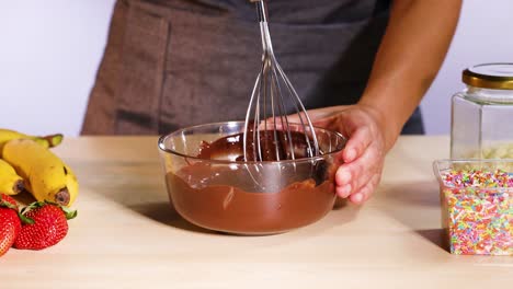 mezclando chocolate con plátanos y fresas