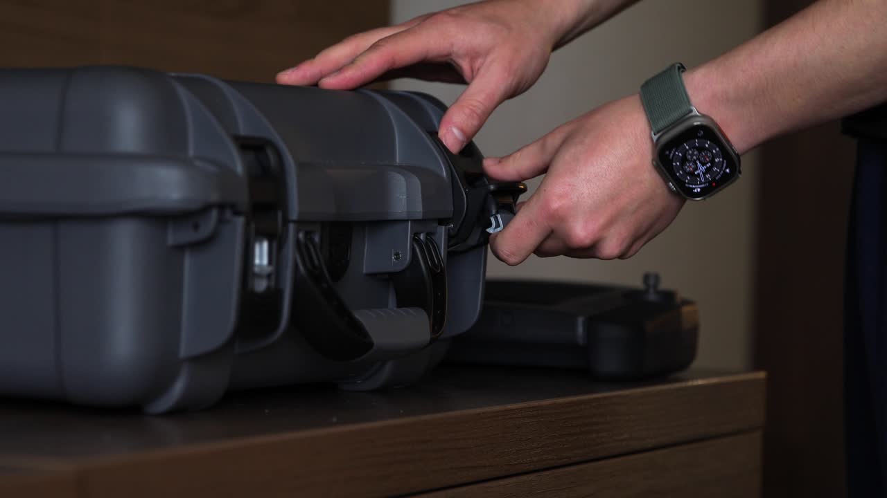 Caucasian male closing a drone case and picking up the controller