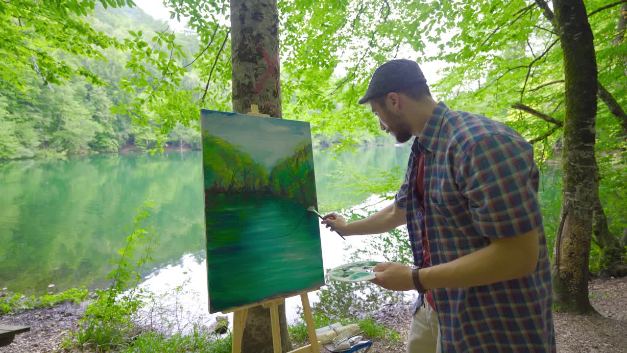 The painter paints landscapes on his canvas.