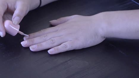 girl painting fingernails a beautiful pink