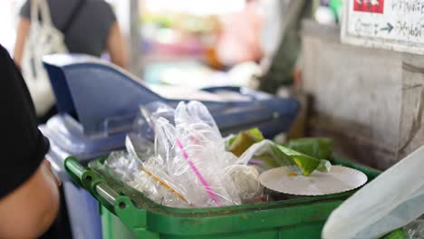 person organizes waste at bangkok floating market