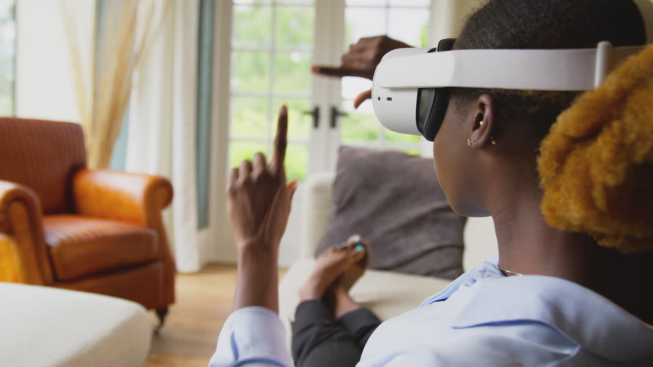 Woman Relaxing Lying On Sofa At Home Wearing VR Headset And Interacting With AR Technology