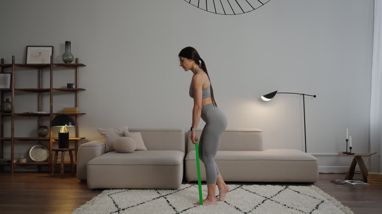 mujer haciendo ejercicio de piernas con banda de resistencia en casa