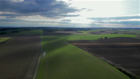 agricultural fields with wind turbines in background aerial 4k video
