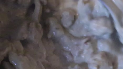 chef cooking and stirring chicken meat on creamy sauce. - close up