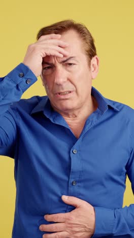 mature man suffering from headache and stomach pain