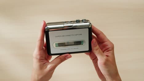 manos sosteniendo un reproductor de cintas de cassette de época