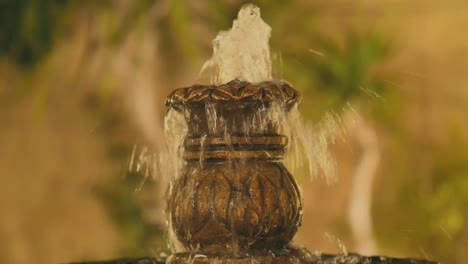 close up view of top of courtyard fountain with water flowing down the side