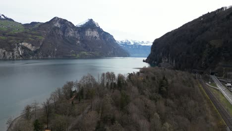 Aerial-Lake-Walensee-in-Switzerland,-Swiss-Alps-peak-with-snow-and-forest