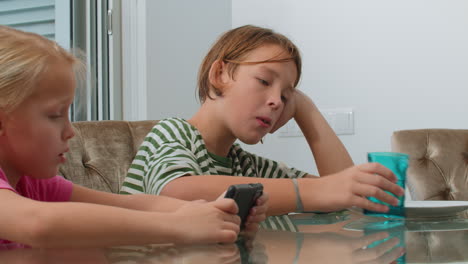 siblings eating and using phones