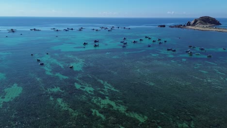 pan left aerial shot showing traditional fishing boats over clear waters at phan rang in ninh hải district, ninh thuận, vietnam