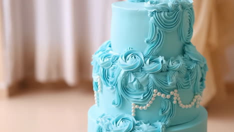 elegant blue tiered cake with rose and pearl decorations