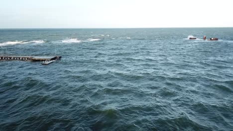 Drone-aerial-around-person-swimming-over-ocean-Melbourne-wavy-windy-cloudy