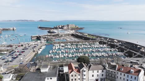 Flug-über-Die-Dächer-Von-St.-Peter-Port-Guernsey-über-Den-Hafen-Zum-Castle-Cornet-Mit-Blick-Auf-Herm,-Jethou-Und-Sark-An-Einem-Klaren,-Hellen-Tag-Mit-Ruhiger-See