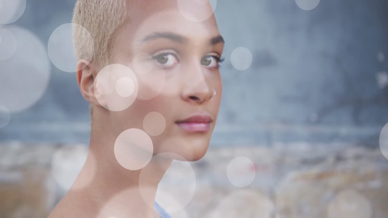 Animation of light spots over biracial woman smiling