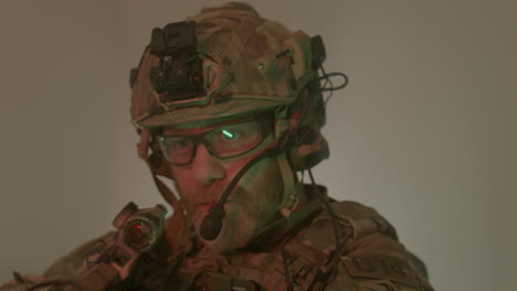 focused bearded man in camouflage uniform taking sight