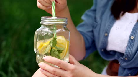 smiling girl in hat enjoys a chilled lemonade on nature