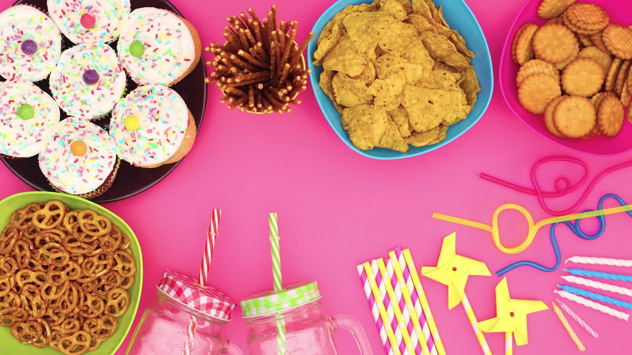 la decoración de la fiesta y la comida aparecen en fondo rosa - detenga el movimiento