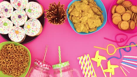 la decoración de la fiesta y la comida aparecen en fondo rosa - detenga el movimiento