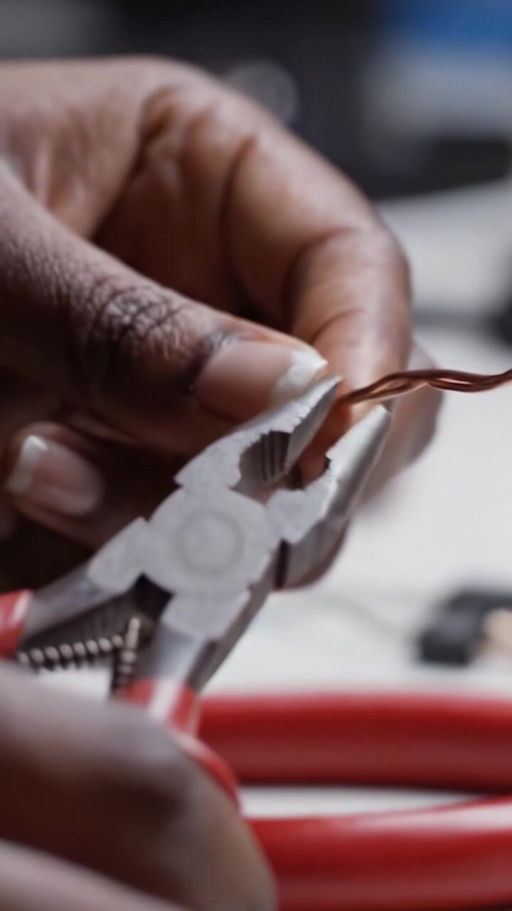 Hands Engaged in Electrical Work: A Close-Up Look at Using Pliers to Manipulate Copper Wires and Ensure Connections in a Wiring Project