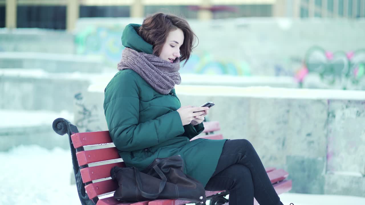 Donna che usa lo smartphone in un parco invernale