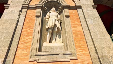 stone statue on a brick wall facade