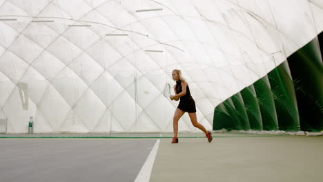 WIDE-SIDE-VIEW-Young-Caucasian-female-tennis-player-hitting-a-ball-during-game-or-practice.-100-FPS-slow-motion,-4K-UHD-RAW-graded-footage