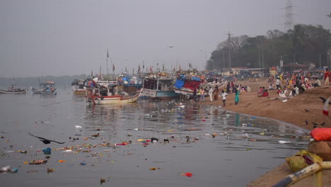 water pollution near a sea shore,flowers, plastics,food,bottles and waste in mumbai city, india, near a small fishing boats docked or parked on shore video background in prores 422 hq