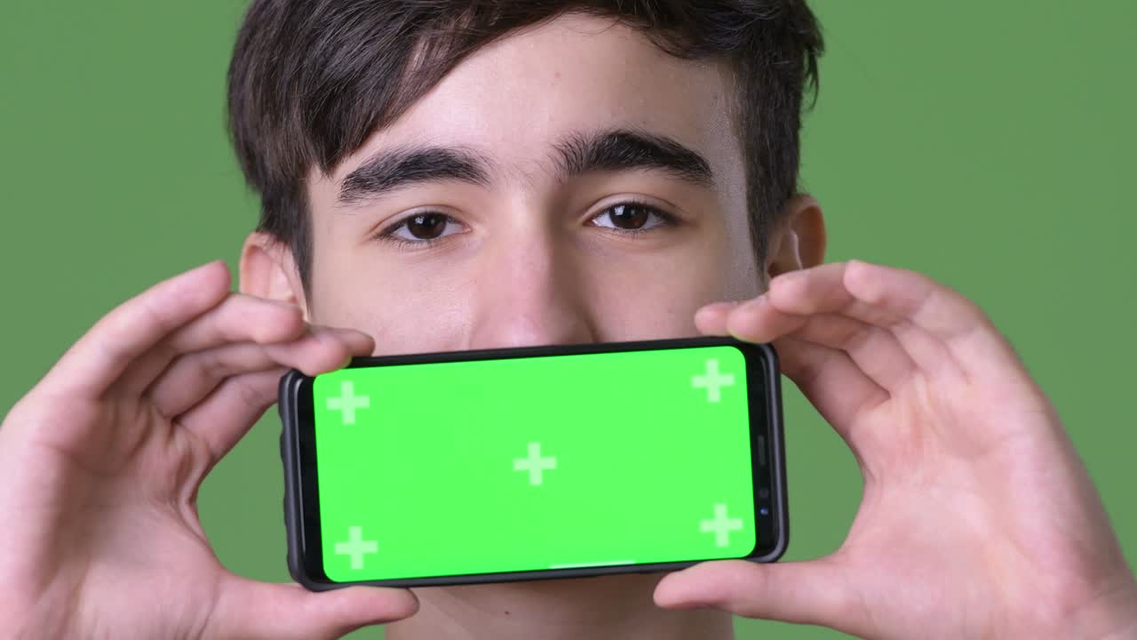 초록색 배경에 젊은 잘생긴 이란 십대 소년