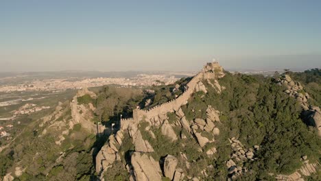 aerial rotating shot of the castelo dos mouros on a rugged mountain in portugal