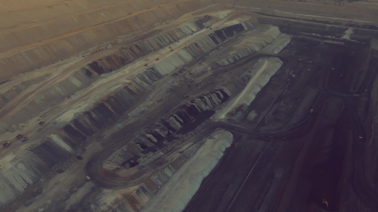 Layered open pit at Thar Engro Coal Mining in Sindh as a drone glides over terraced benches and haul roads.