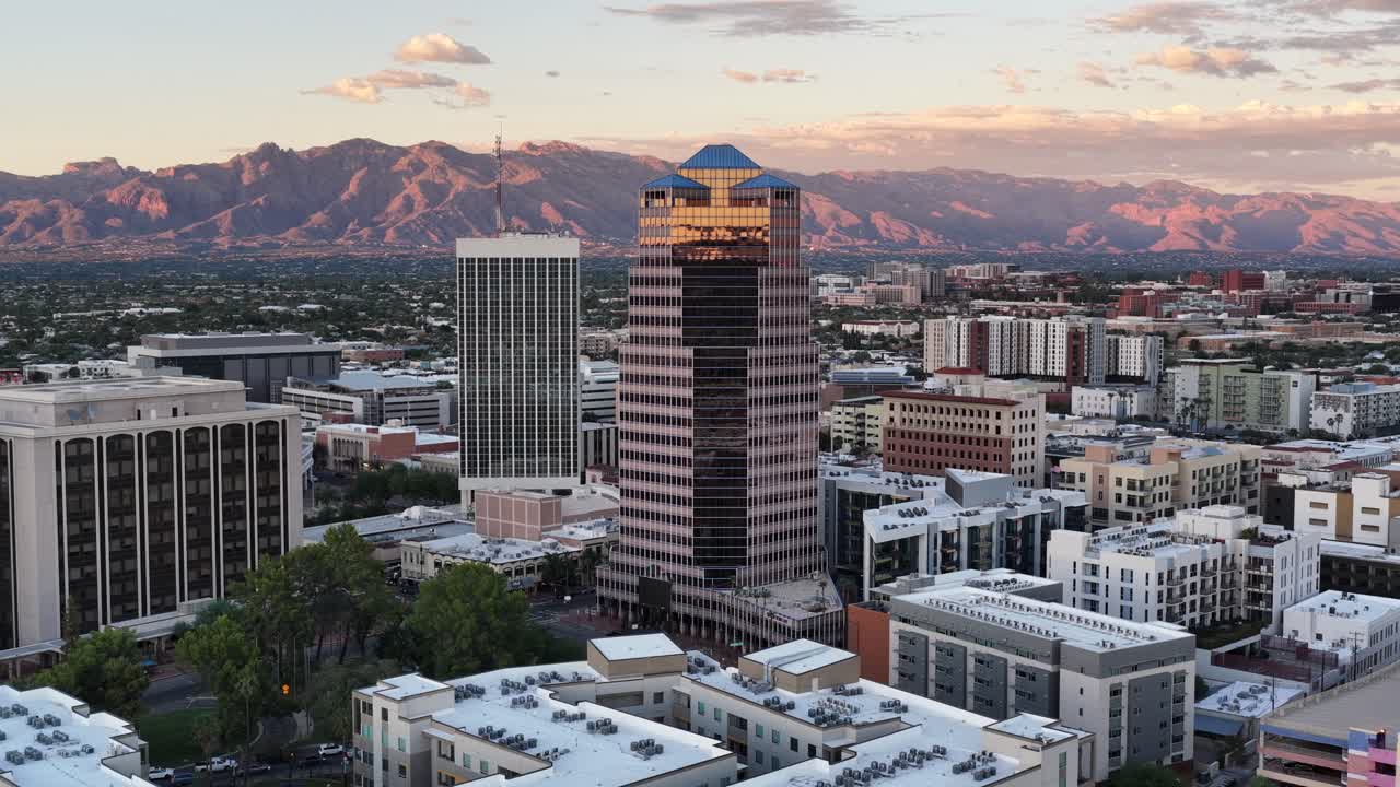 Ascending drone shot of downtown Tucson, Arizona at sunset with Catalina Mountains in background