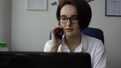 mujer hablando por teléfono en la oficina