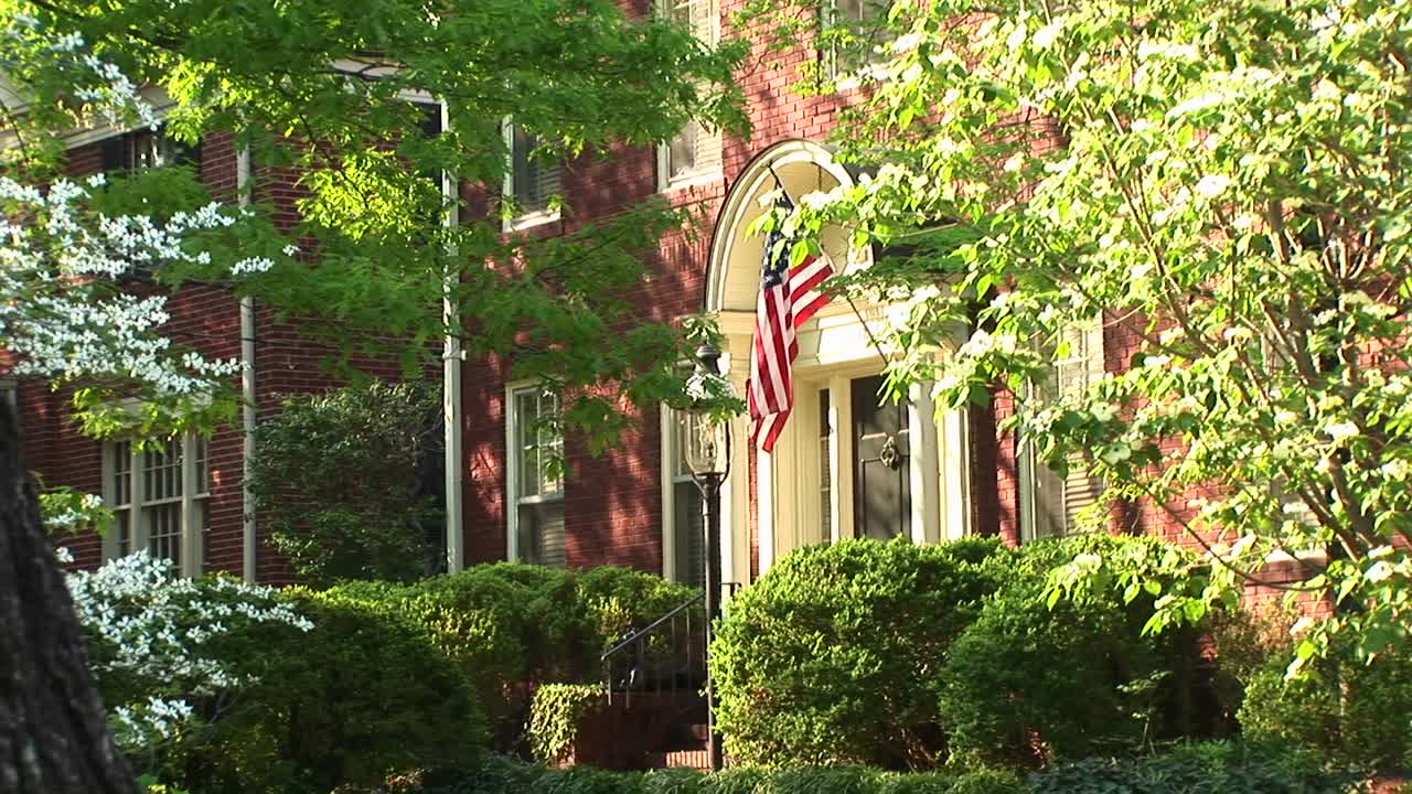 나무 사이로 보이는 미국 국기가 집 출입구 옆에 자랑스럽게 걸려 있다