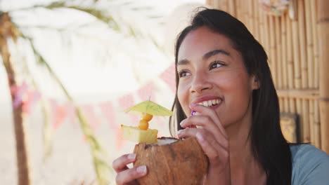 young mixed race woman drinking cocktail