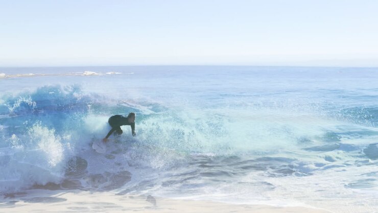 Animation of landscape with ocean over caucasian male surfer surfing