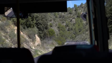 pov of interior of bus driving through mediterranean countryside