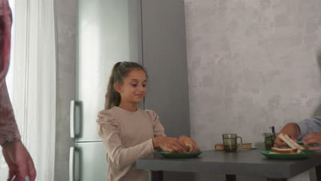 kids at kitchen table, one excitedly gesturing while other looks bored, casual breakfast scene, morning light, simple family interaction, relaxed home environment, kitchen setting