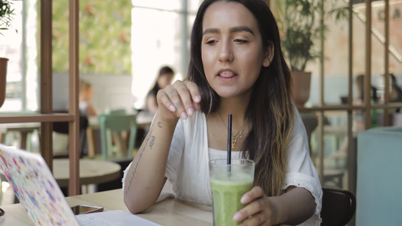 Giovane donna che beve un frullato fresco
