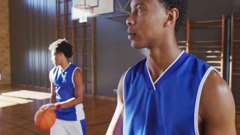 portrait of african american male basketball player with teammate in background
