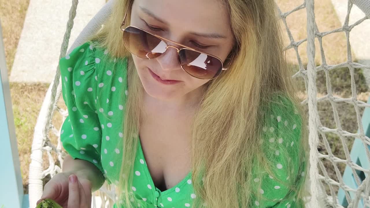 매달린 의자 에서 먹는 여자