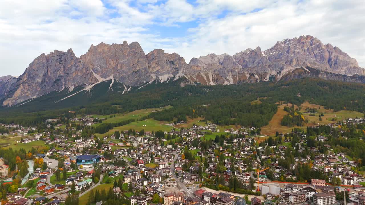 Drone shots reveal Cortina’s cozy town embraced by Italy’s towering peaks.