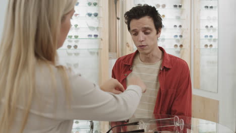 customer trying on glasses in an optical store