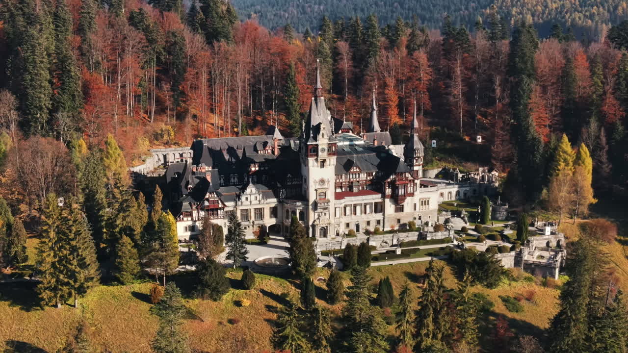 Aerial drone view of The Peles Castle in Romania. Castle with gardens in Carpathians, forest around it, tourists
